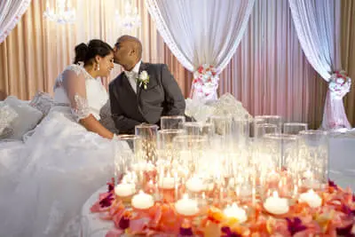 Newlyweds kiss behind floating candle decor at an elegant wedding reception coordinated in Georgia