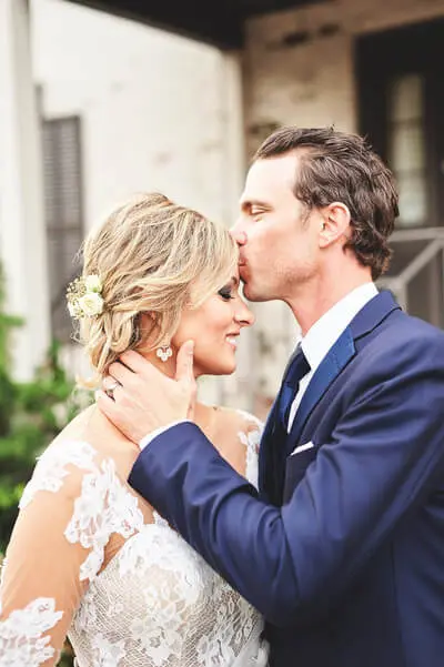 Groom kisses bride’s forehead during romantic outdoor South Asian wedding moment in Atlanta